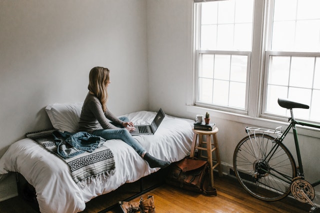 woman-in-gray-shirt-sitting-on-bed-3954635